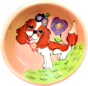 Sweet King Charles sitting in flowers dog bowl